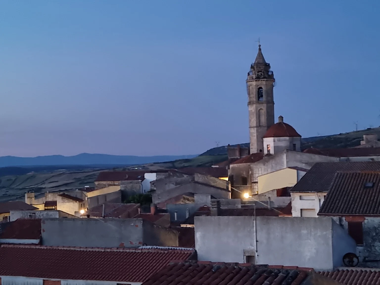 The church tower and rooftops of Nulvi at dusk