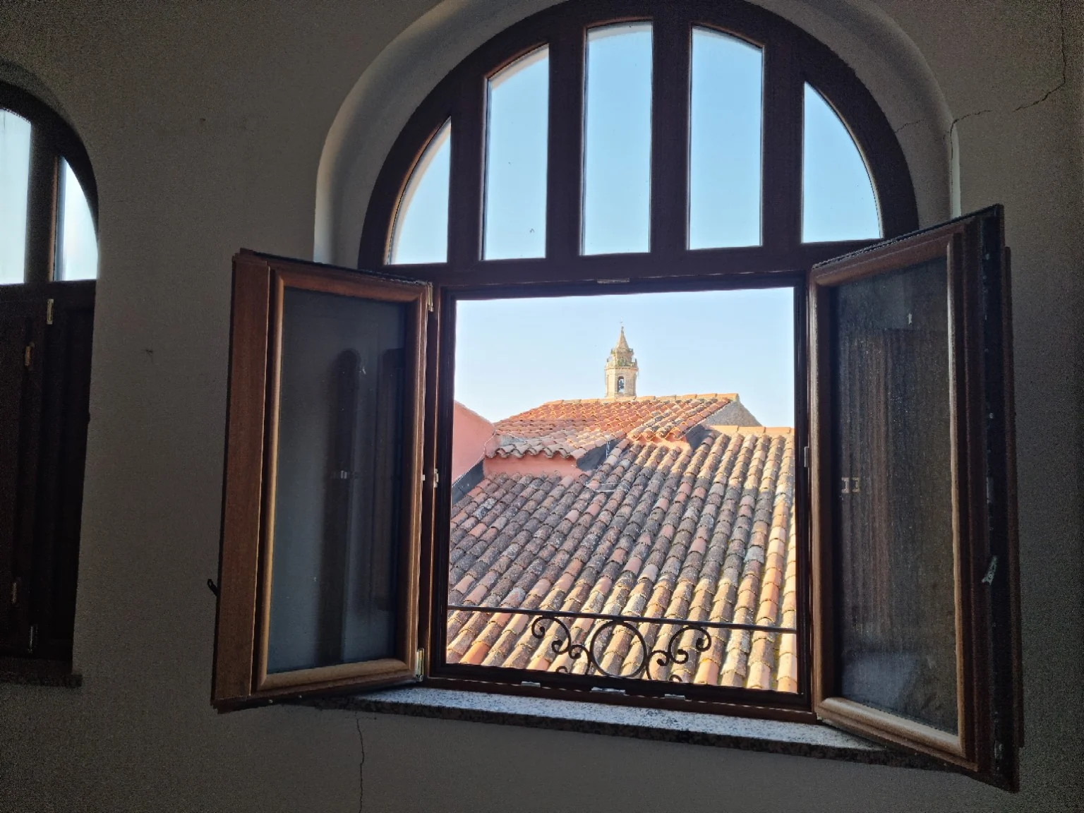 An arched window framing the rooftops
